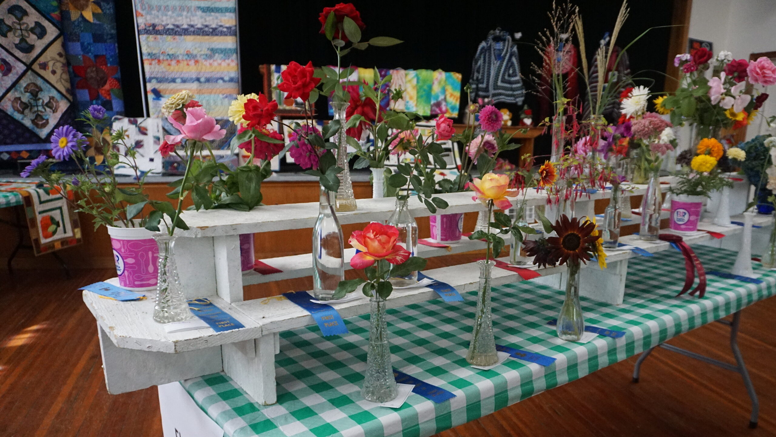 Display from the community fair of the flower entry]ies, image includes ribbons on the winning bouquets