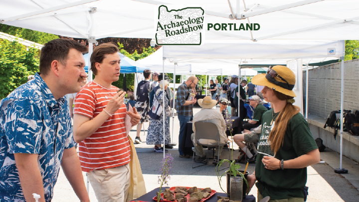 A photo of two individuals learning from a volunteer outside at a booth with rocks on the table. On top of the image is the logo for the Archaeology Roadshow Portland.